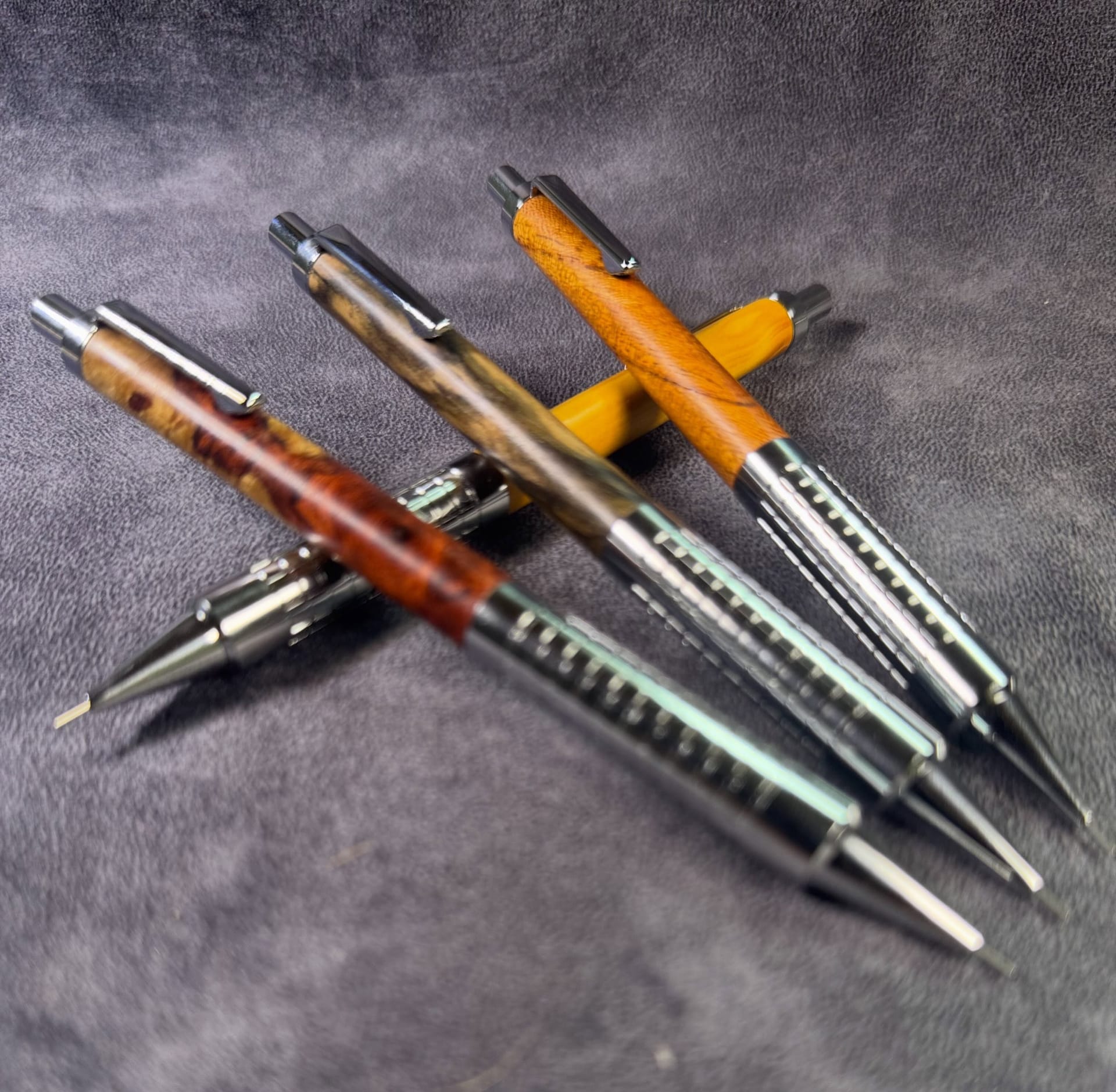 Four Craft A MP204 wooden mechanical pencils with metal grips on a gray cloth.